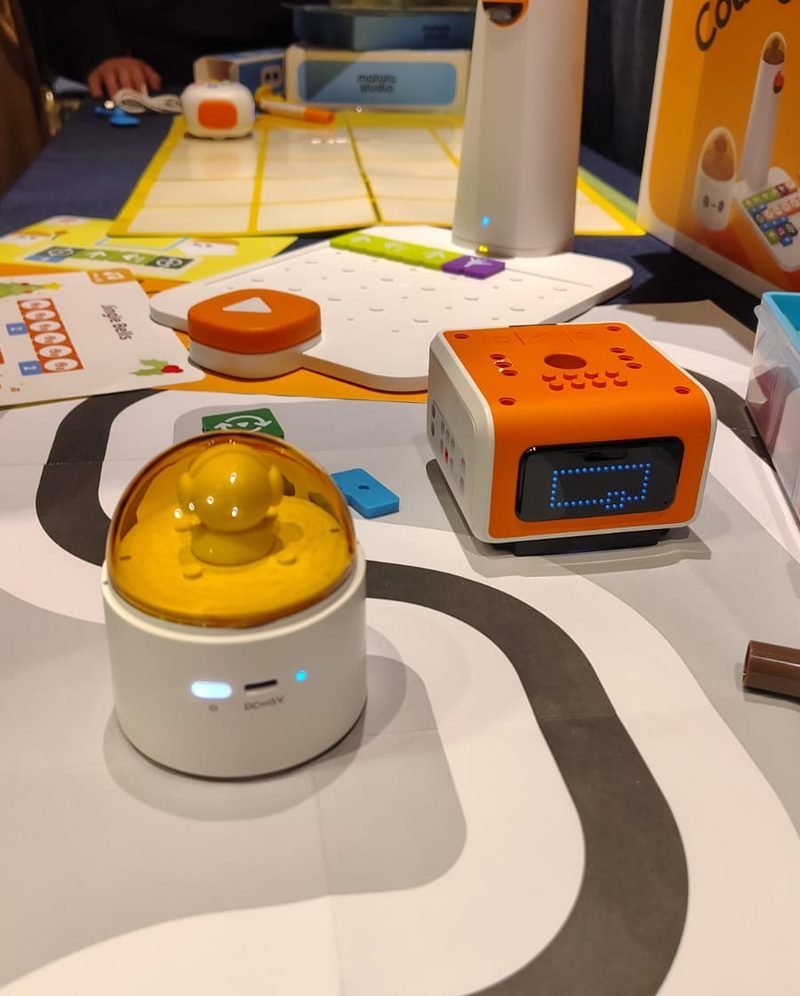 Robots educativos y tarjetas de programación sobre una pista dibujada en la mesa